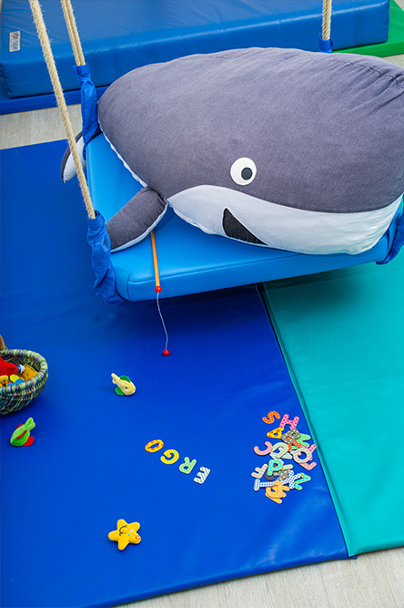Schaukelbereich mit Spielmatten und Buchstaben